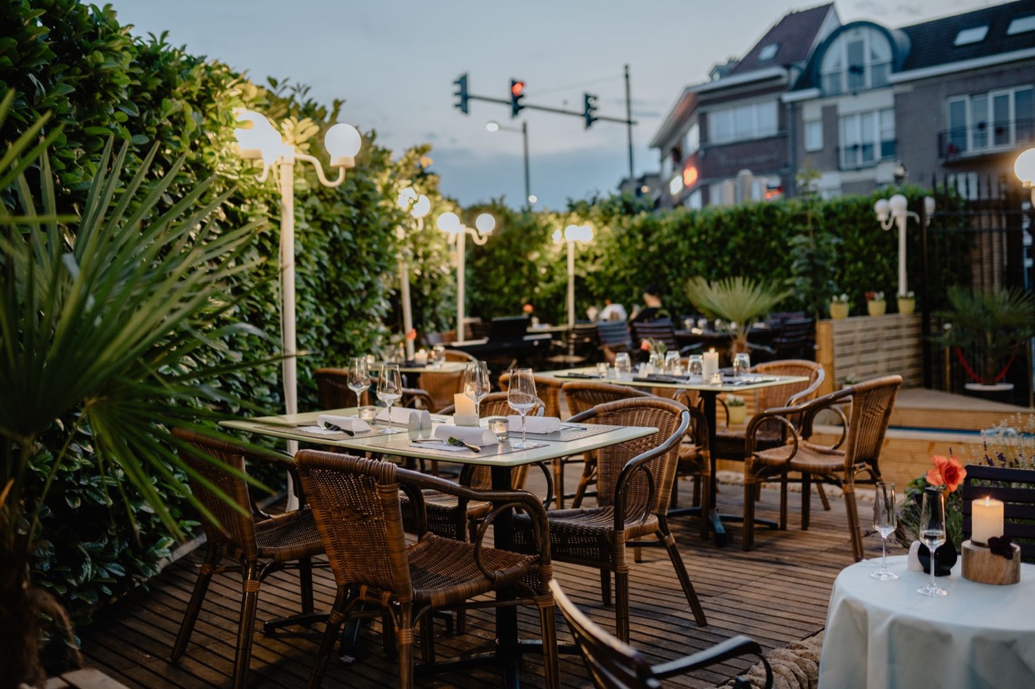Tables dressées en terrasse à la tombée du soir
